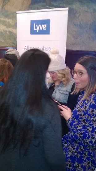 Mom bloggers  mill around the LYVE App device  